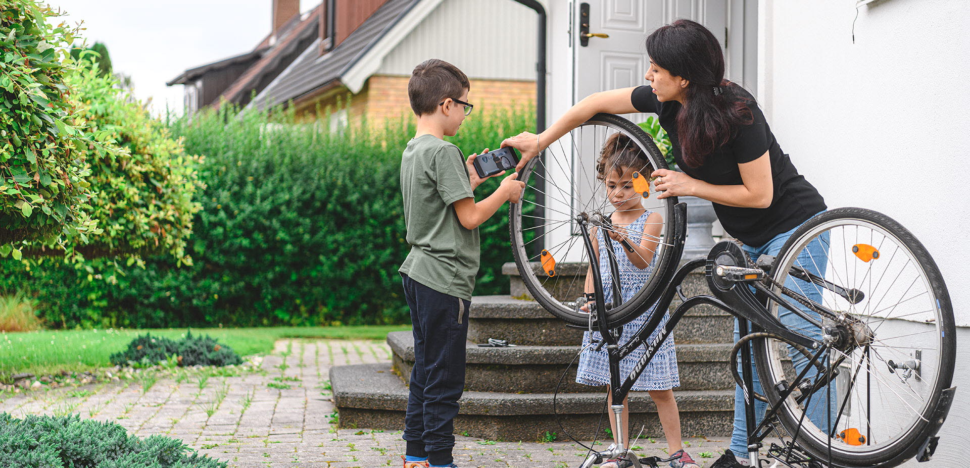 Familj lagar cykeln utomhus med hjälp av en Youtube-video