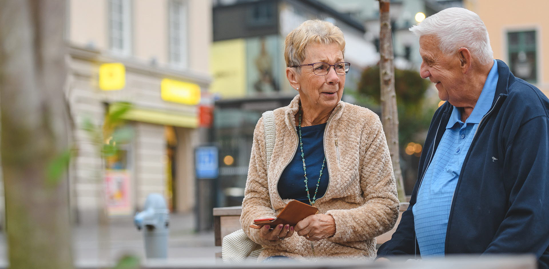 Pensionärer använder mobil på staden i Linköping